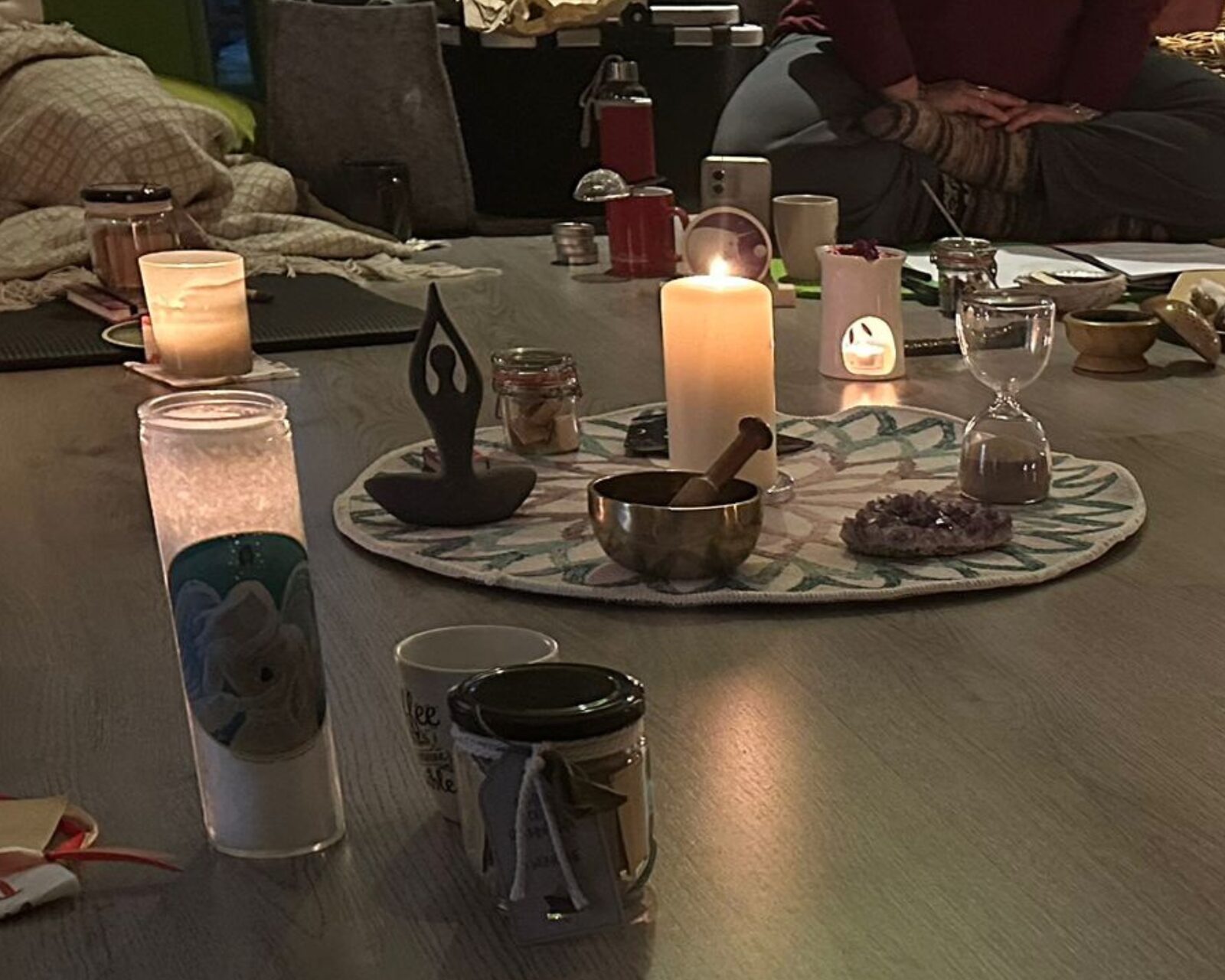 Ritual-Mitte bei Kerzenschein mit Klangschale, Amethyst und Sanduhr während eines früheren Rauhnächte-Nachmittags
